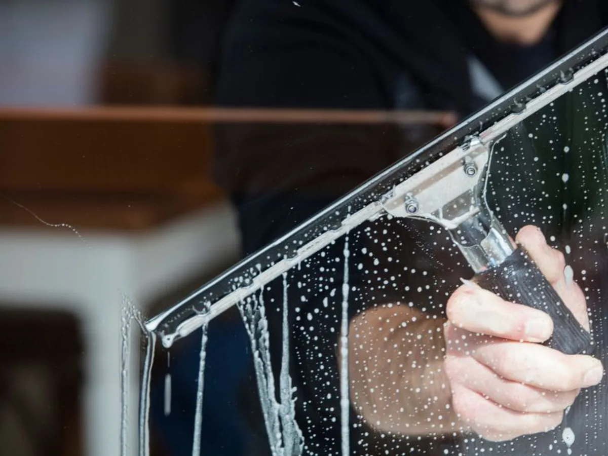 Fensterreinigung mit Abzieher an einer großen Glasfläche